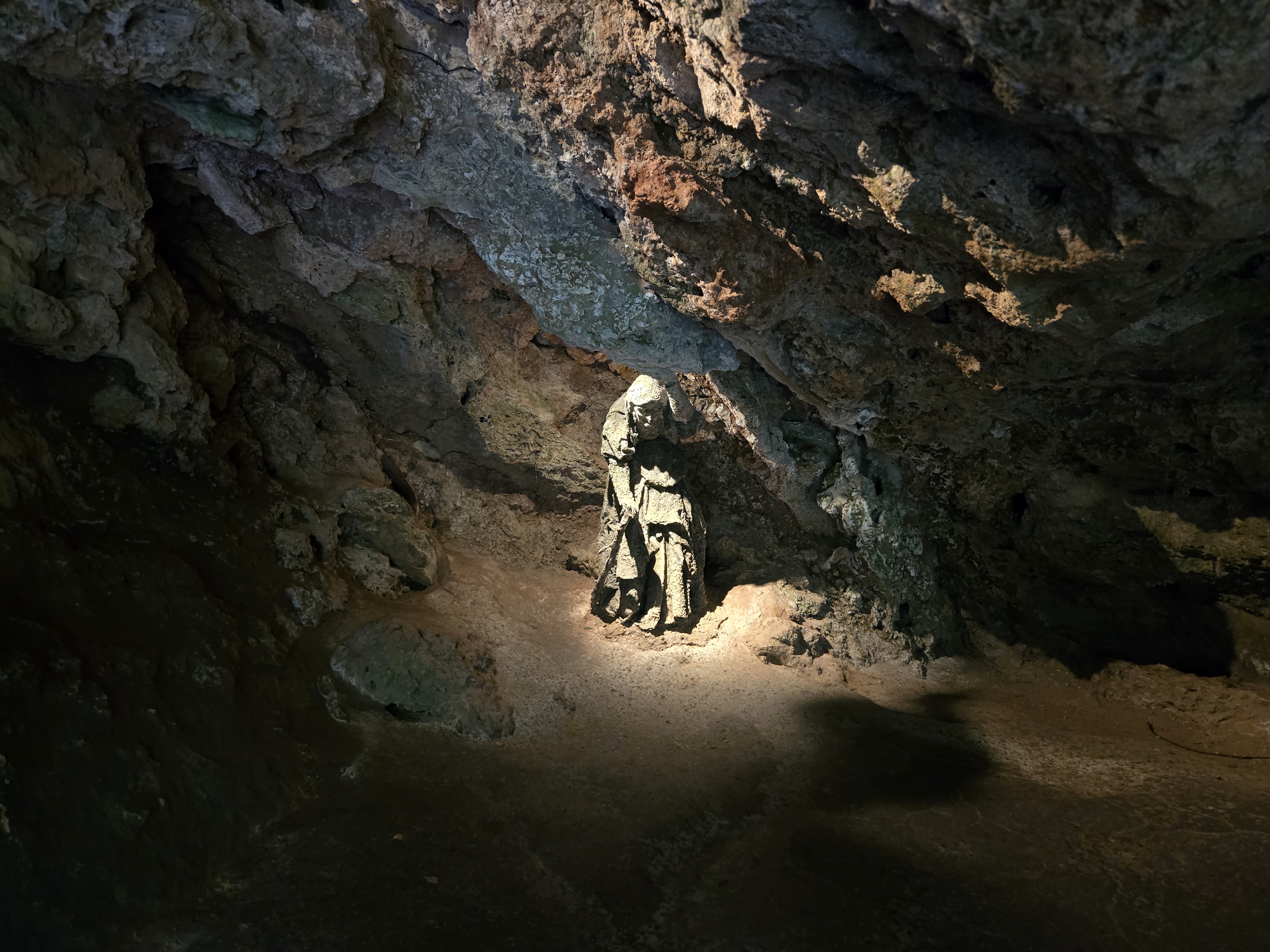 stone statue of old woman in cave